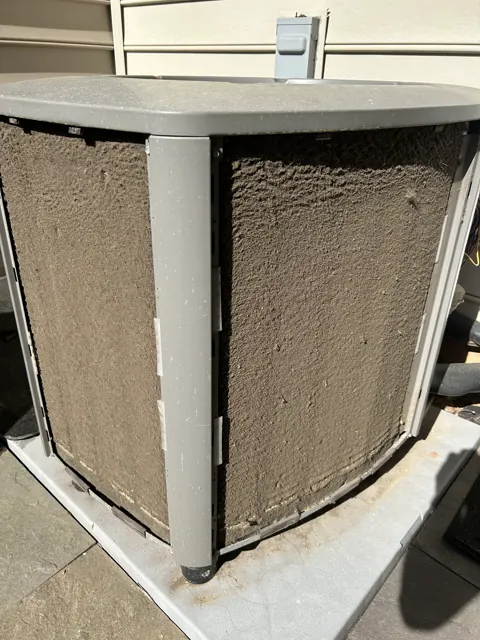 Before: Close view of an outdoor air conditioner coil with visible buildup